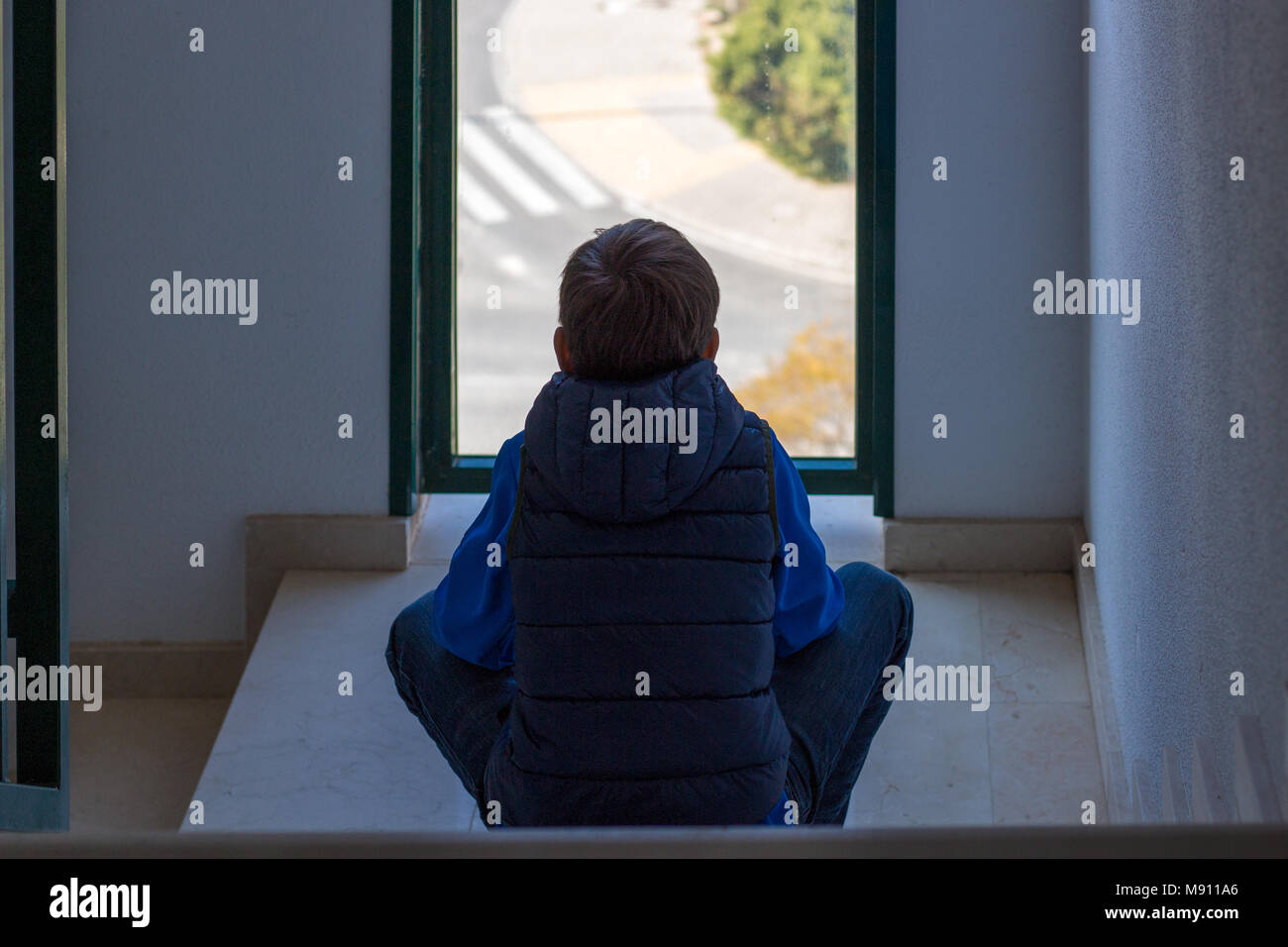 Sad Boy Sitting Alone Sitting In Front Of The Window In The Staircase