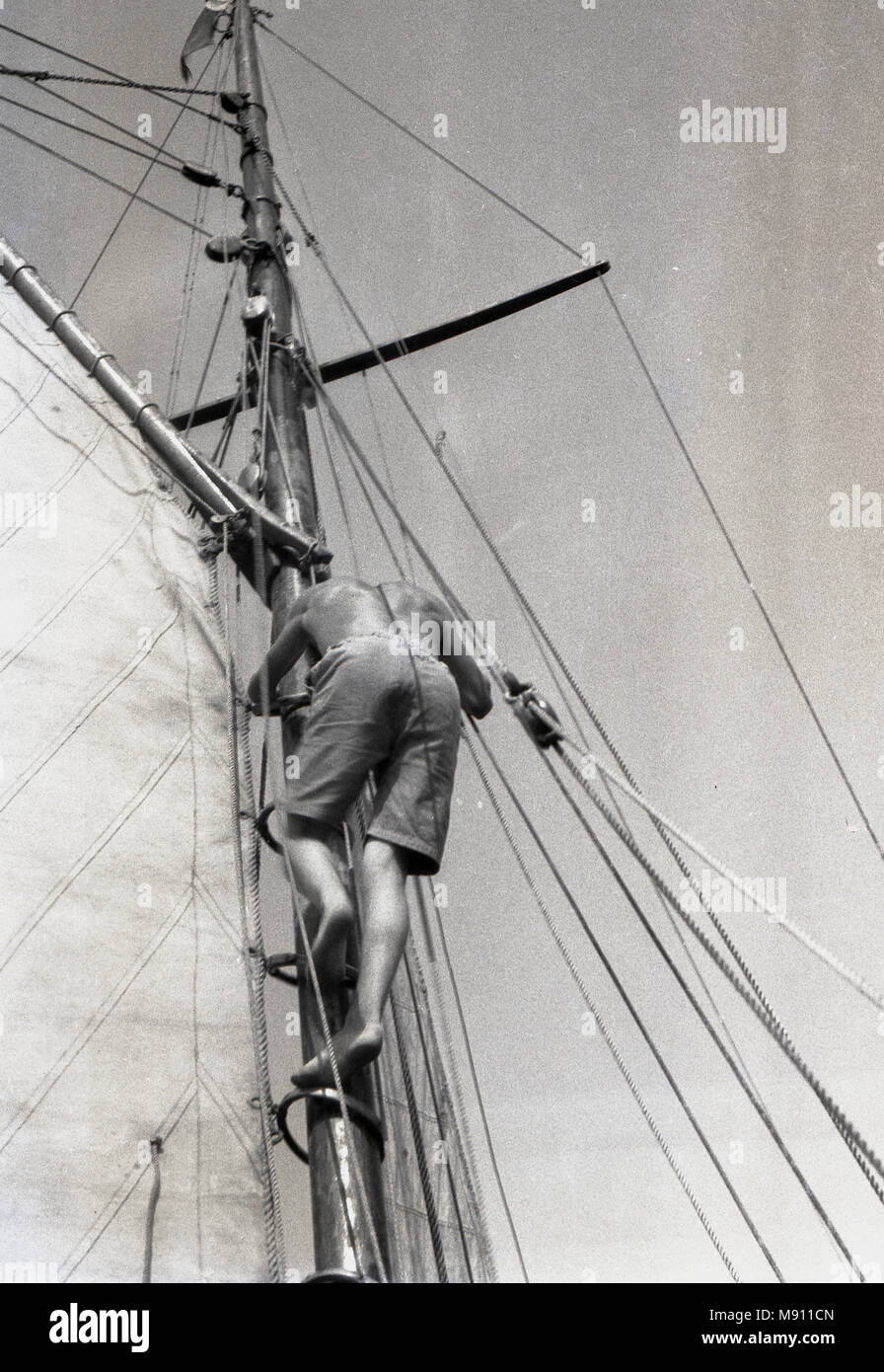 1970s, sailor climbing up or going aloft a mast on a boat on his own unaided,  England, UK. Stock Photo