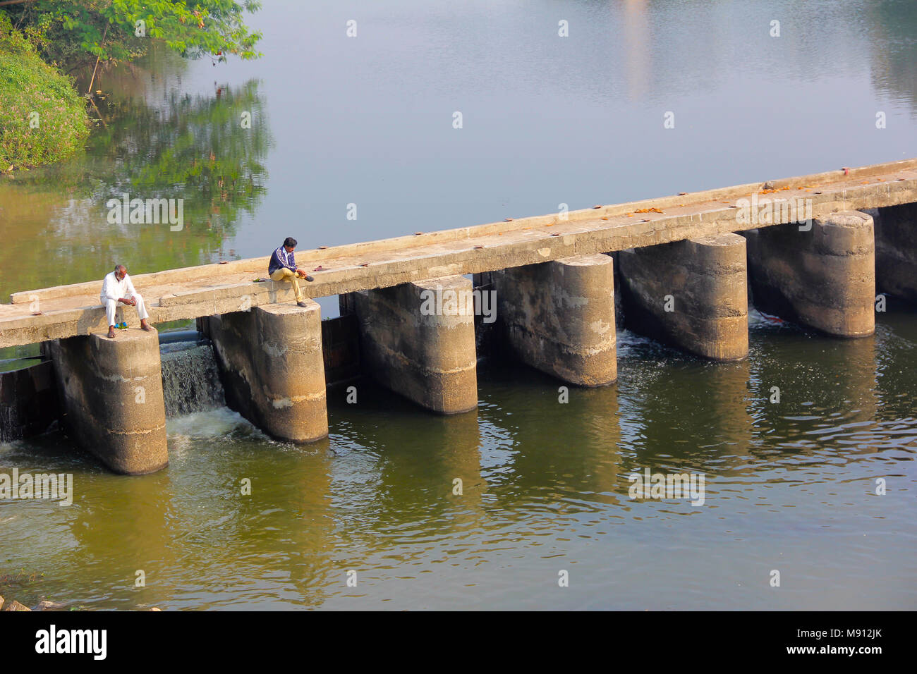 Aerial shot with two men sitting on small bridge over the river, Chinchwad at Pune Stock Photo