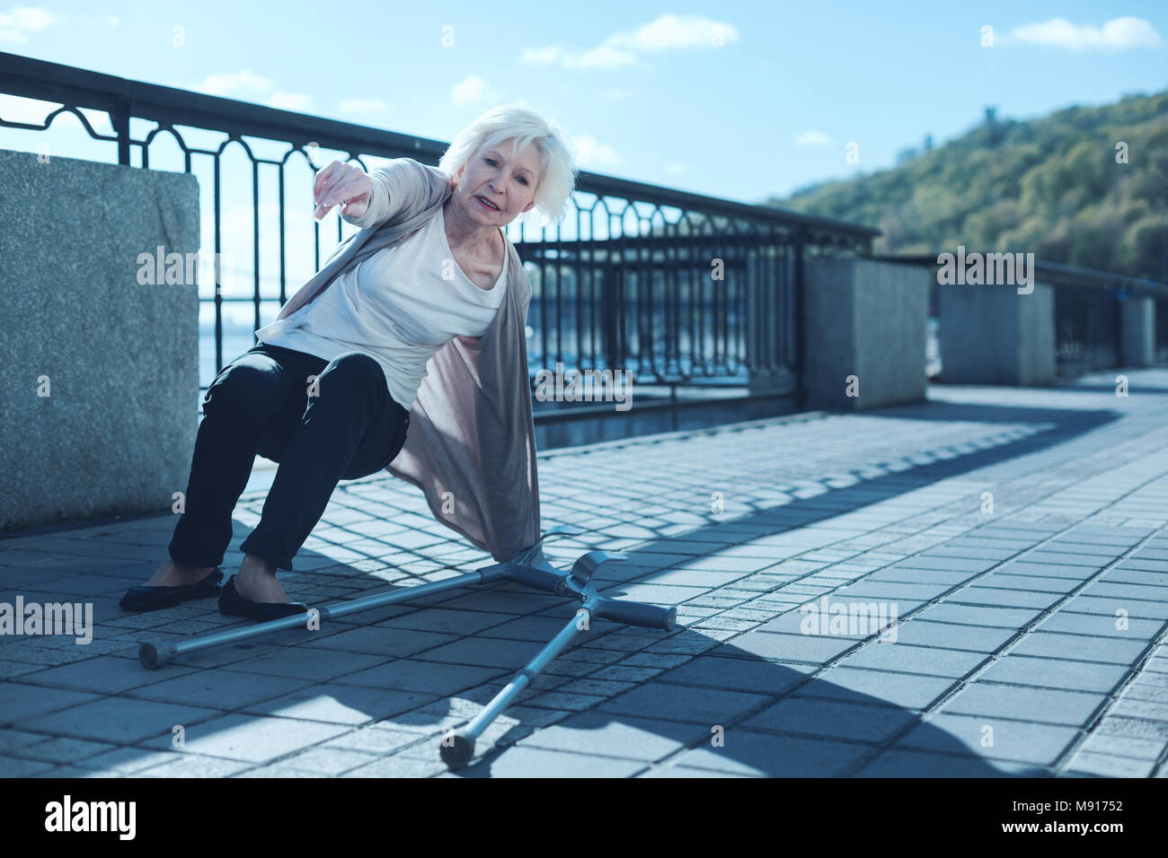 Physically exhausted older woman standing up after falling with