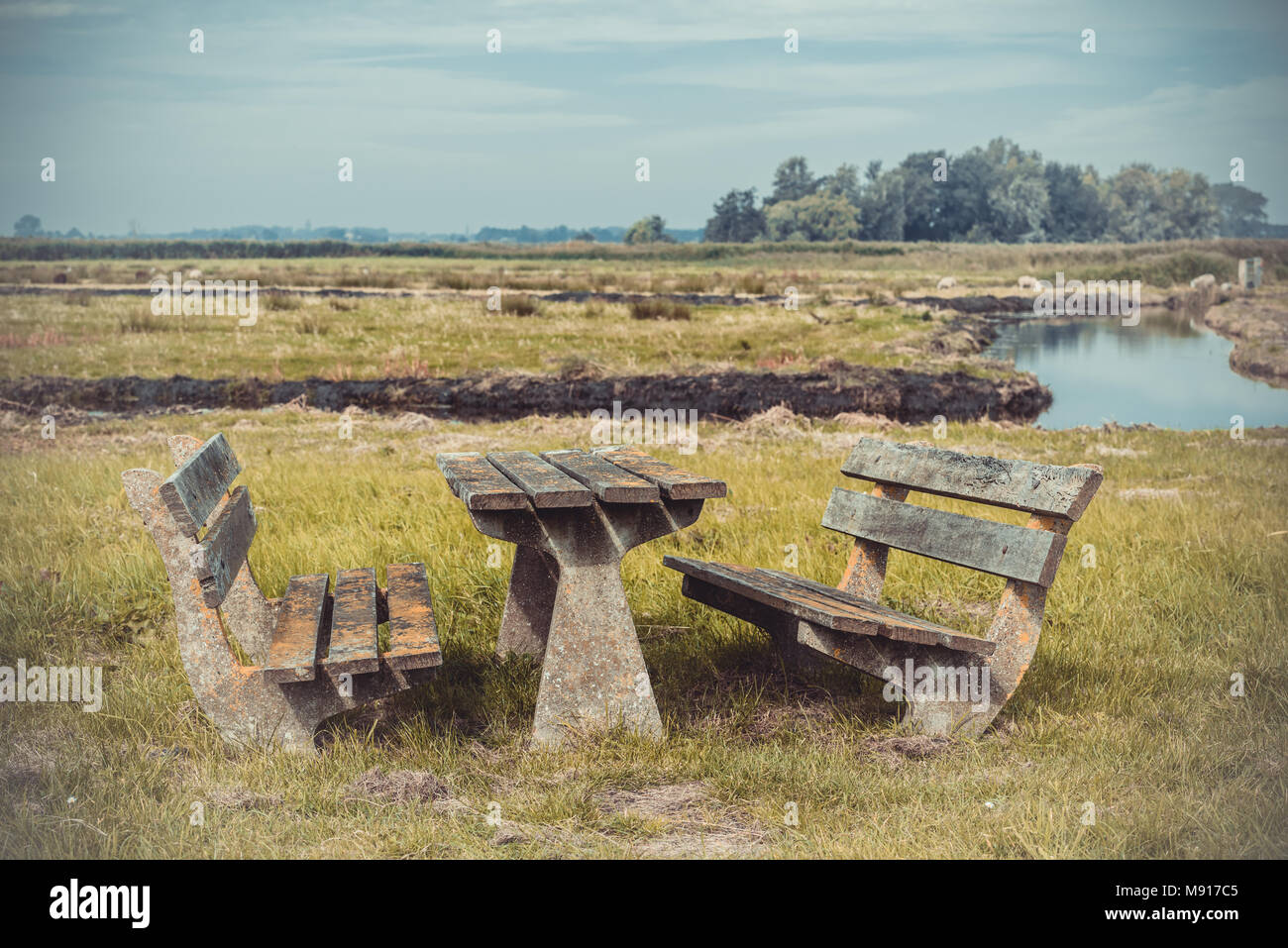 Empty Wooden table and benches in resting area at roadside near river Stock Photo