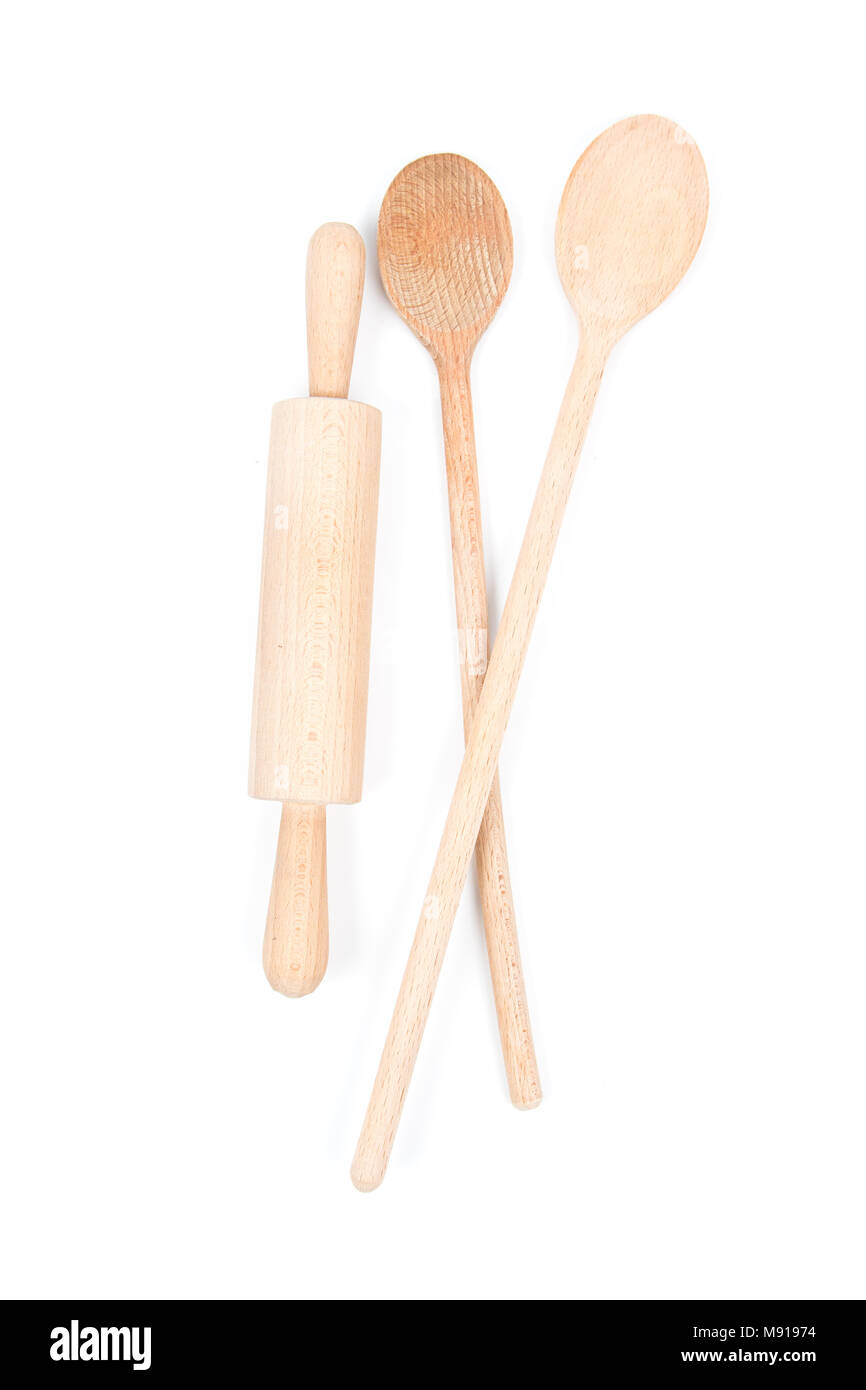Big wooden stirring spoon and small rolling pin isolated on white