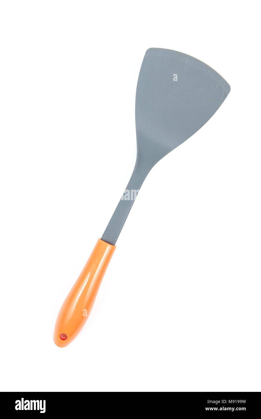 Grey plastic kitchen spatula with orange handle isolated on white background, surface. Kitchen accessory. Stock Photo