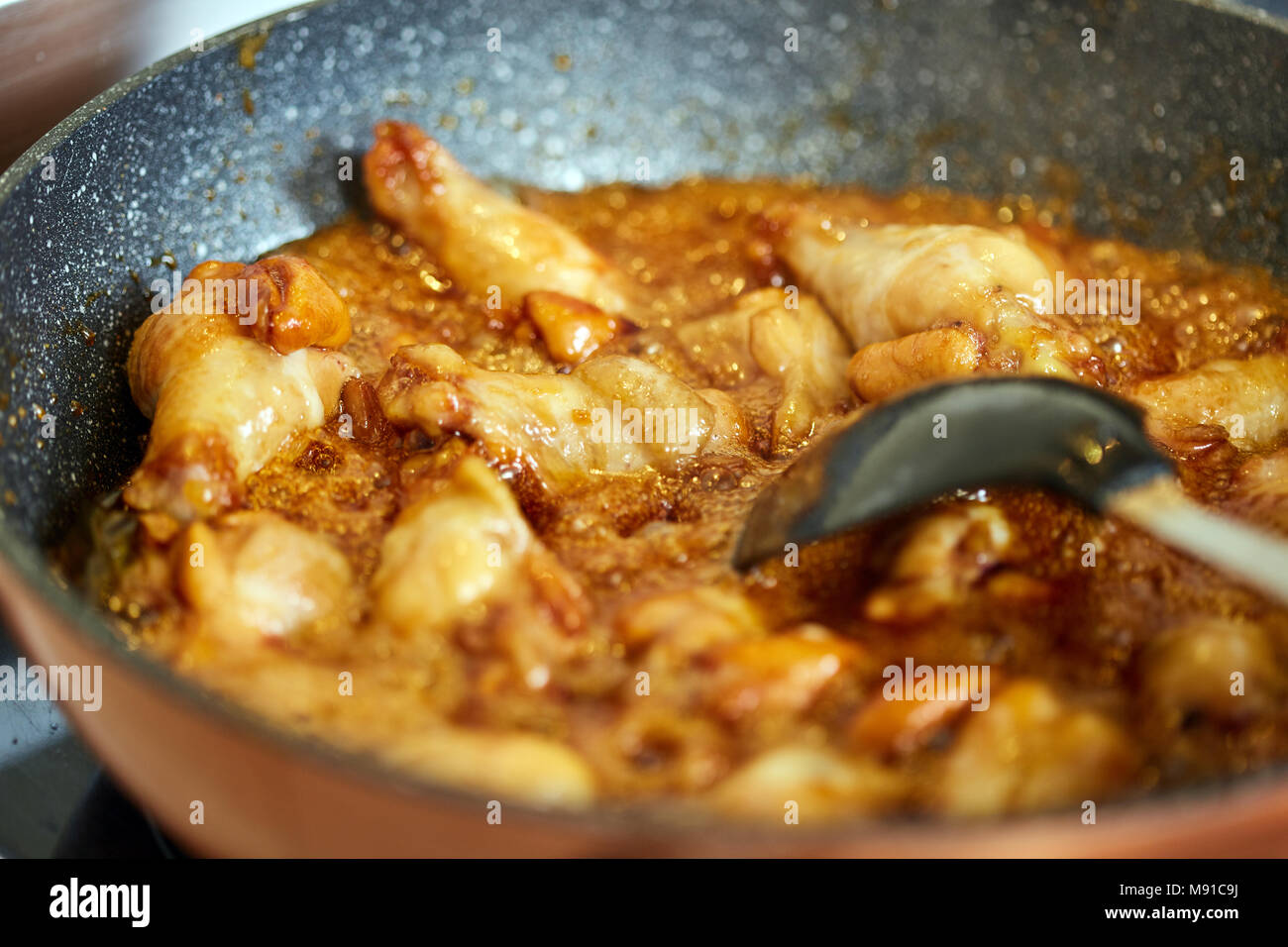 Closeup of caramelized chicken wings in a wok cooking, thai recipe Stock Photo Alamy