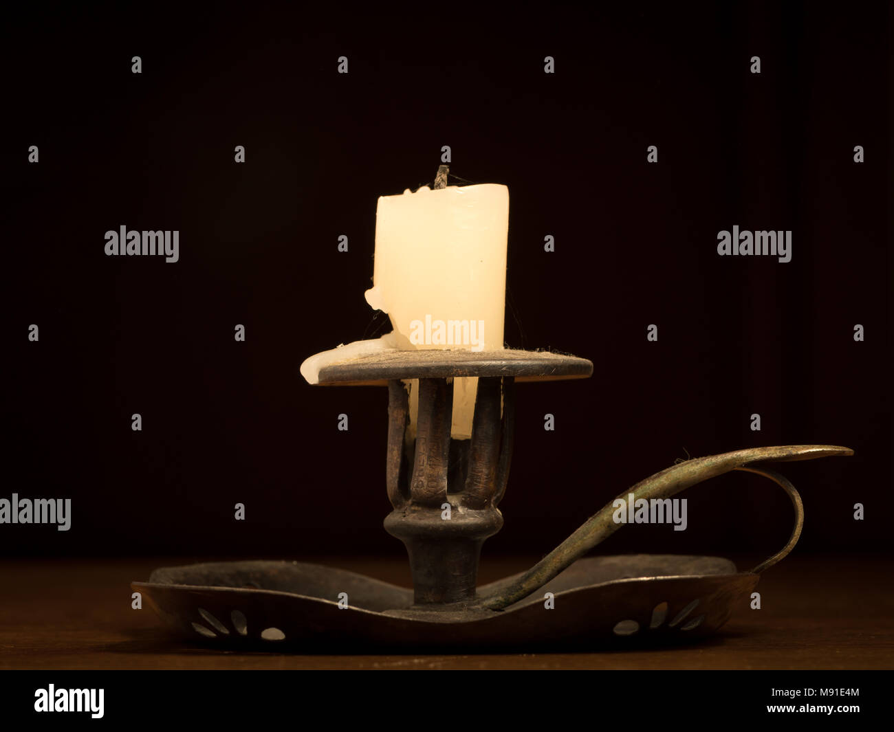 Nearly burnt down candle on an old metallic candle holder Stock Photo