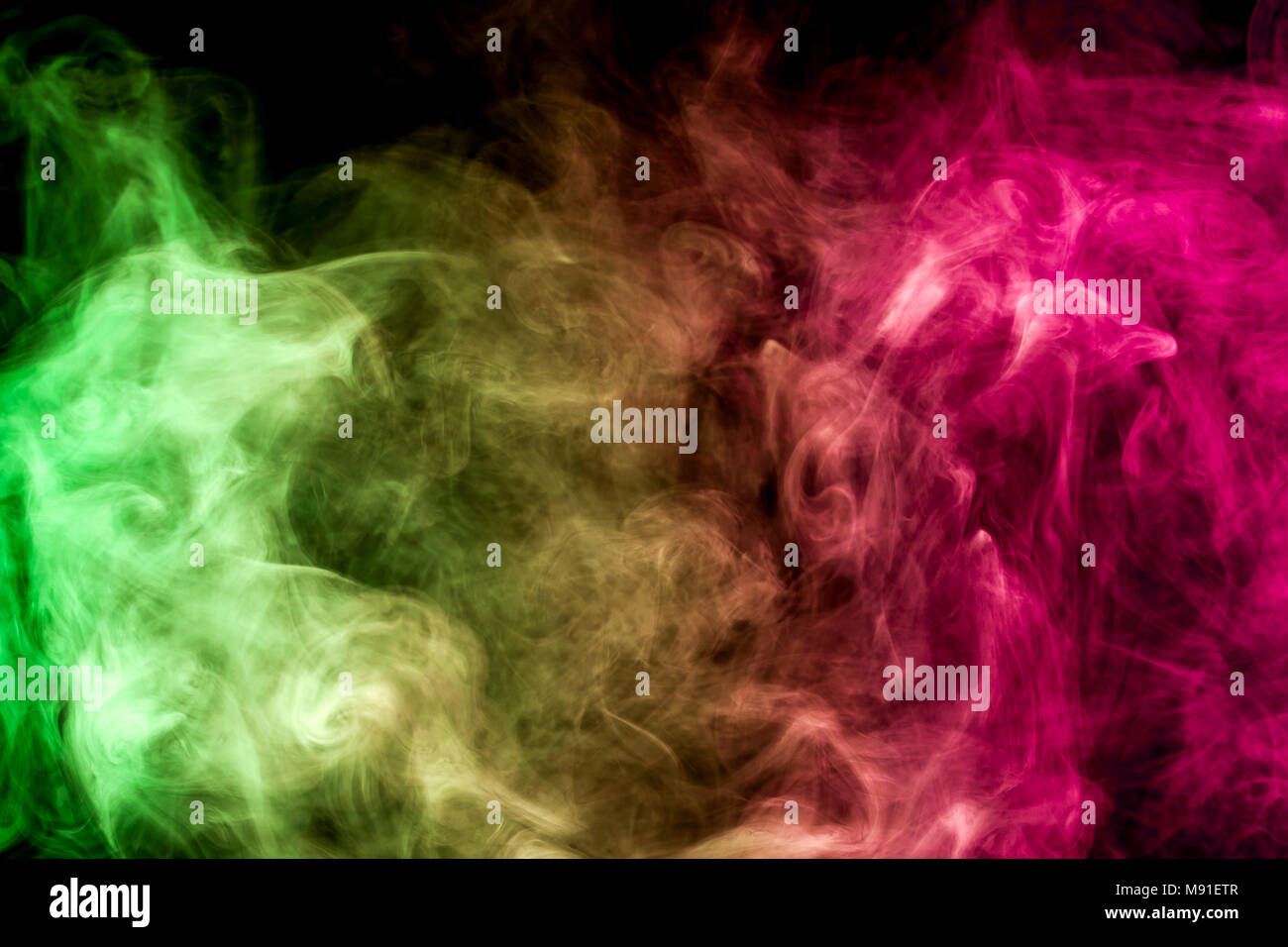 Thick colorful smoke of yellow, pink and green on a black isolated  background. Background from the smoke of vape Stock Photo - Alamy