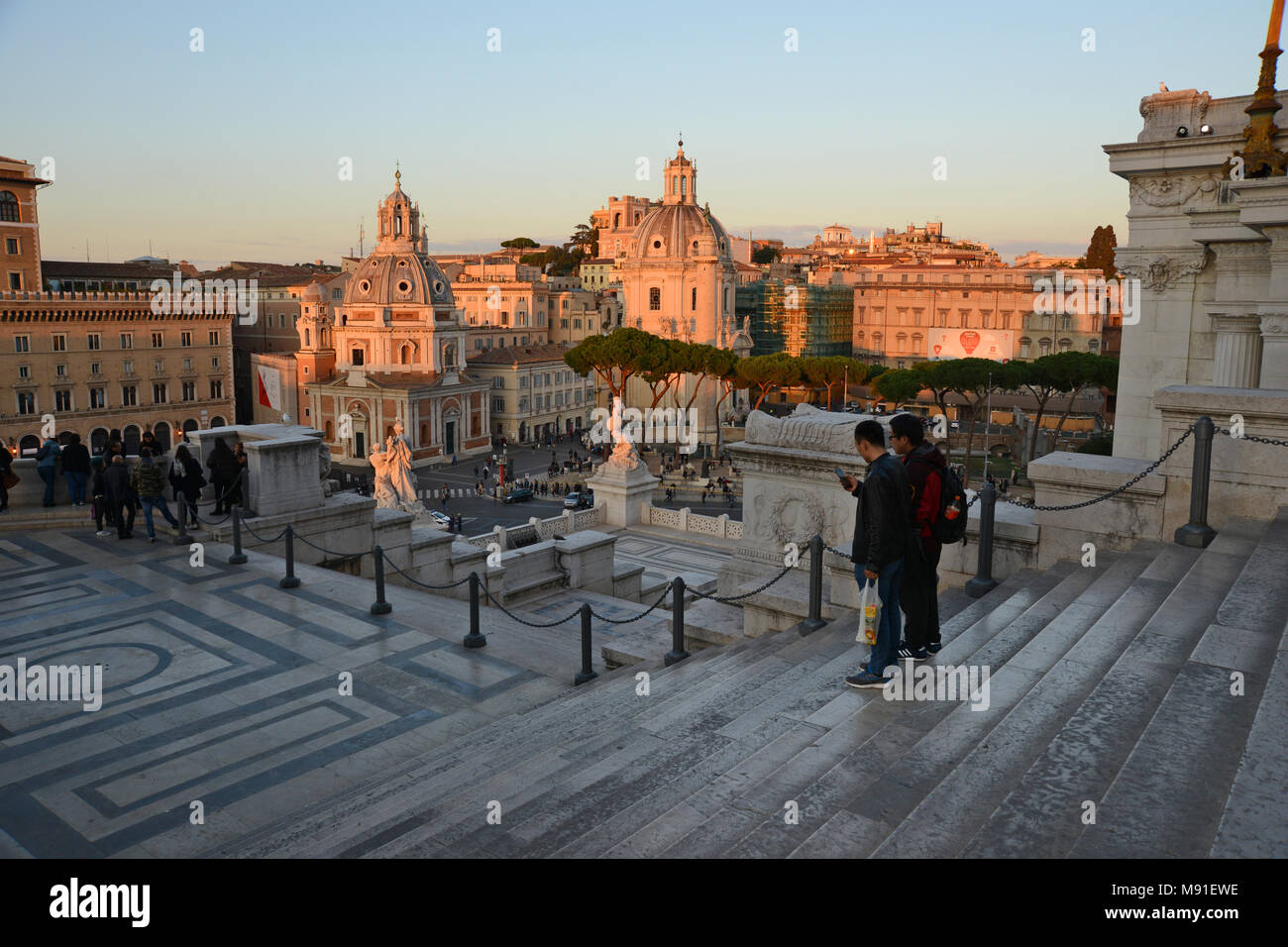 Steps with two people standing leading down from the Altare della Patria in Rome Italy in autumn evening light Stock Photo