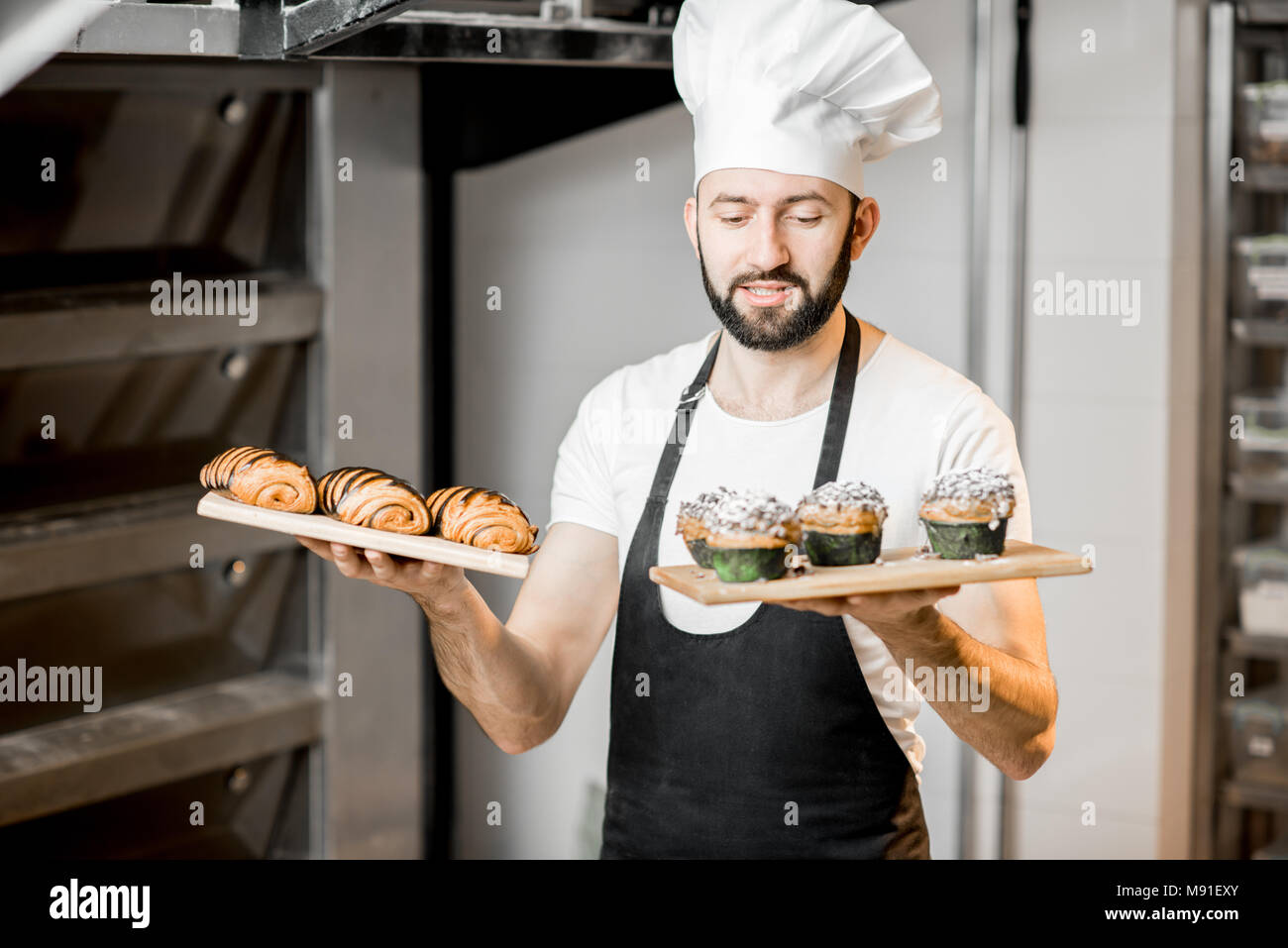 Confectioner with sweet pastry in the manufacturing Stock Photo