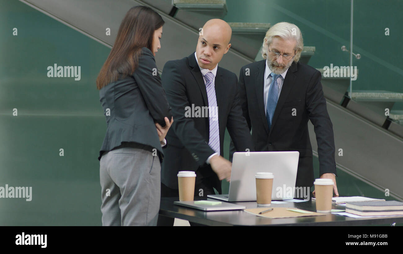 multiethnic corporate people meeting in office discussing business using laptop computer in modern office. Stock Photo