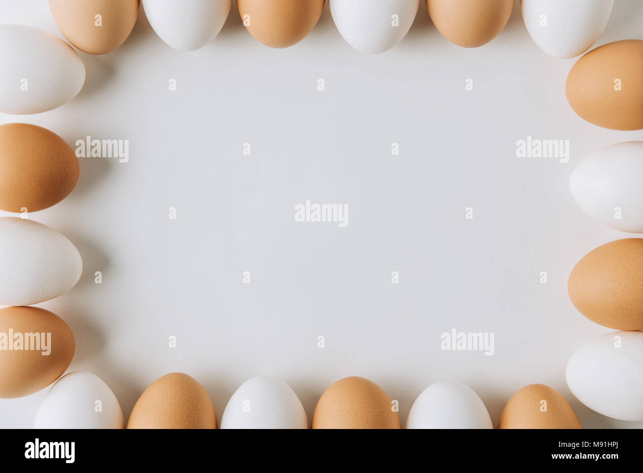 white and brown eggs laying on on white background and forming square Stock Photo