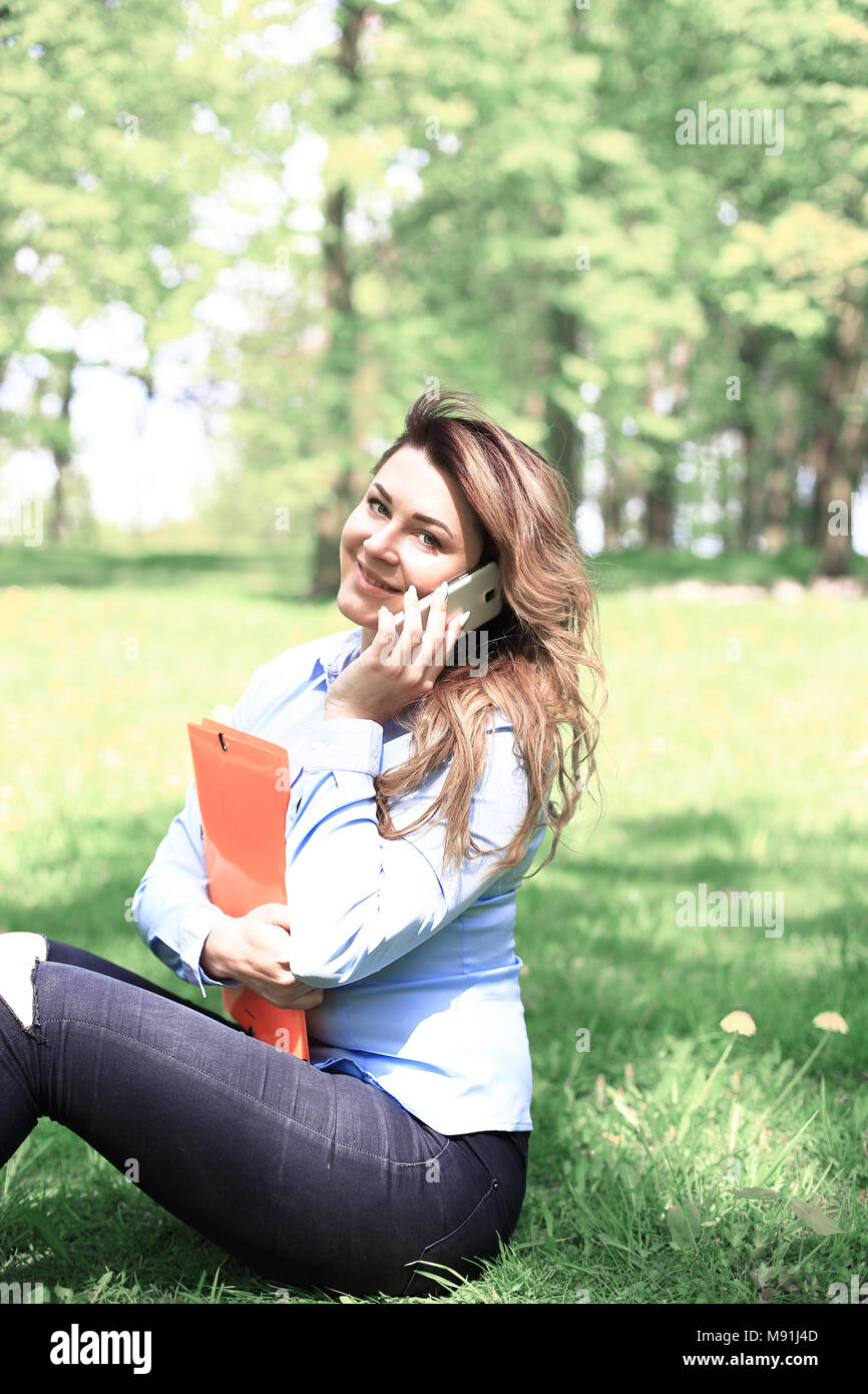 young pretty girl working on laptop outdoor, lying on grass, caucasian 20 years old Stock Photo