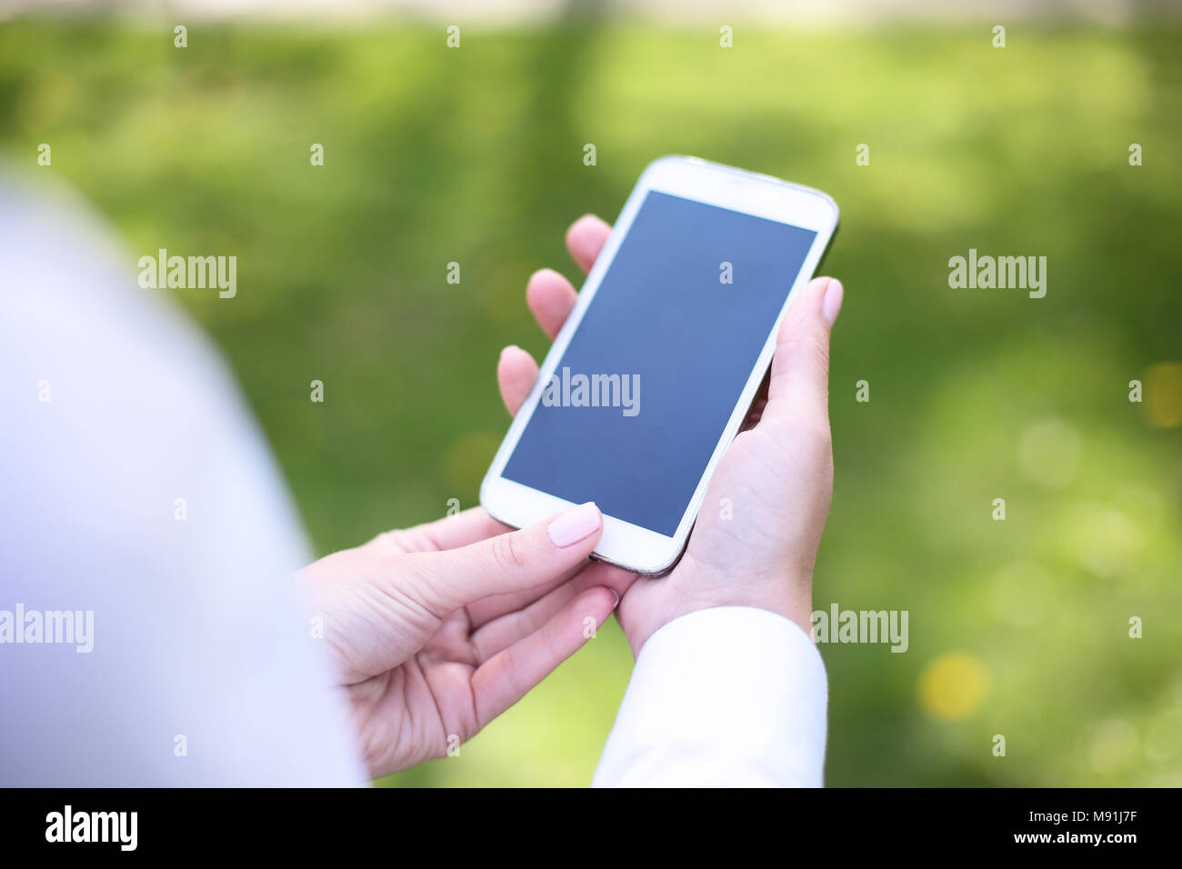 Woman using mobile smart phone in park. Stock Photo