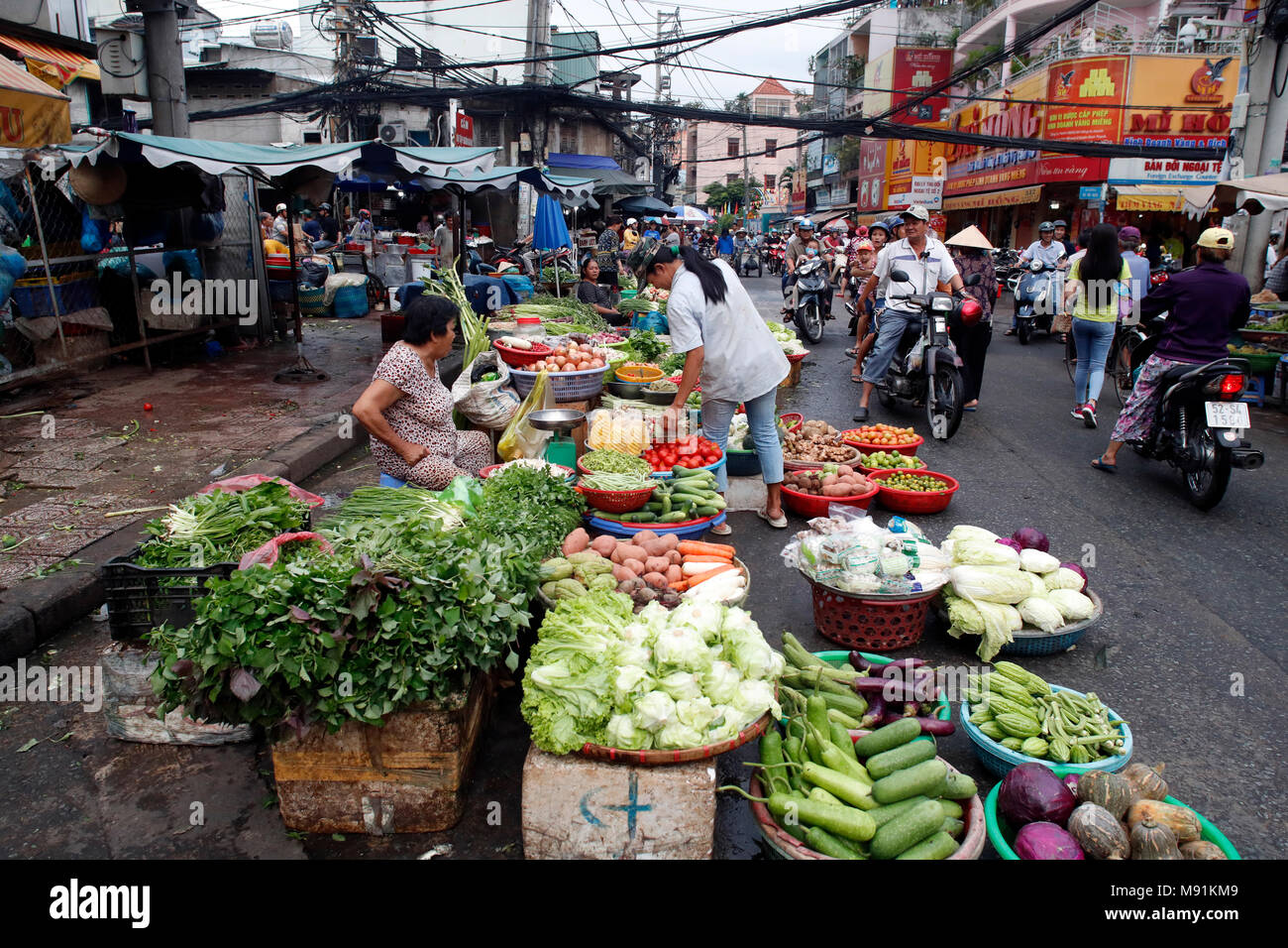 Market and motorbikes on chaotic street life traffic. Ho Chi Minh City. Vietnam. Stock Photo