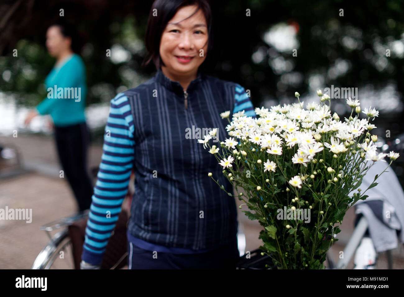Woman buying flowers at market.  Hanoi. Vietnam. Stock Photo