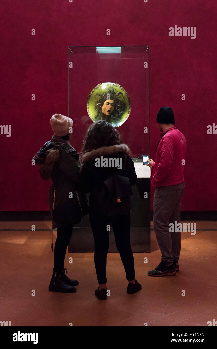Florence. Italy. Uffizi Gallery. Visitors viewing the Medusa painted wooden shield, by Caravaggio (ca. 1598). Galleria degli Uffizi.  The eight rooms  Stock Photo