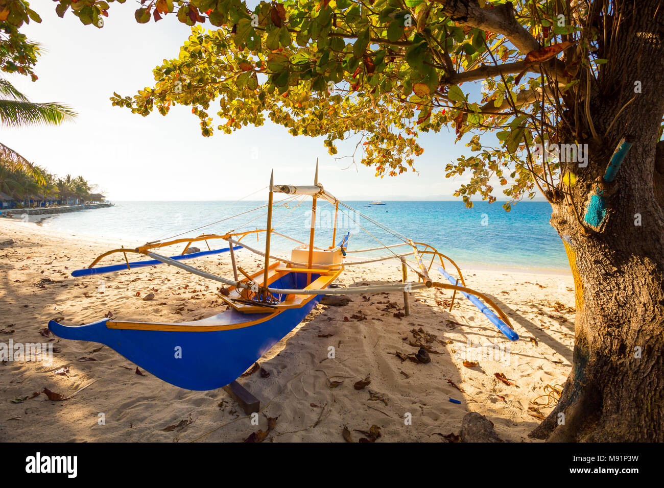 Backlit raditional filipino banca boat on a beach at sunset, Palawan, Philippine Stock Photo