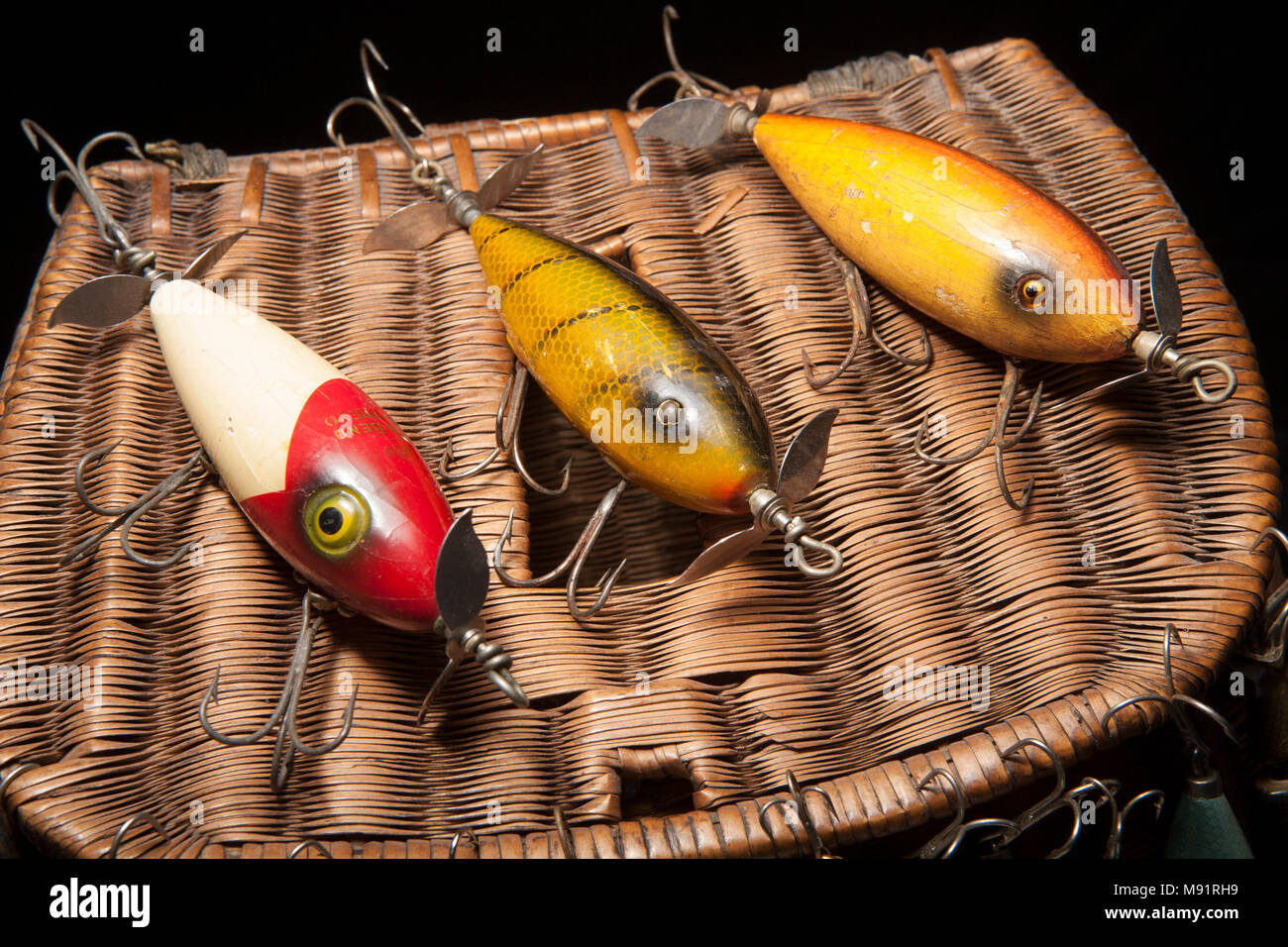 Old fishing lures or plugs by South Bend, on a creel and black background, from a vintage fishing tackle collection in the UK Stock Photo