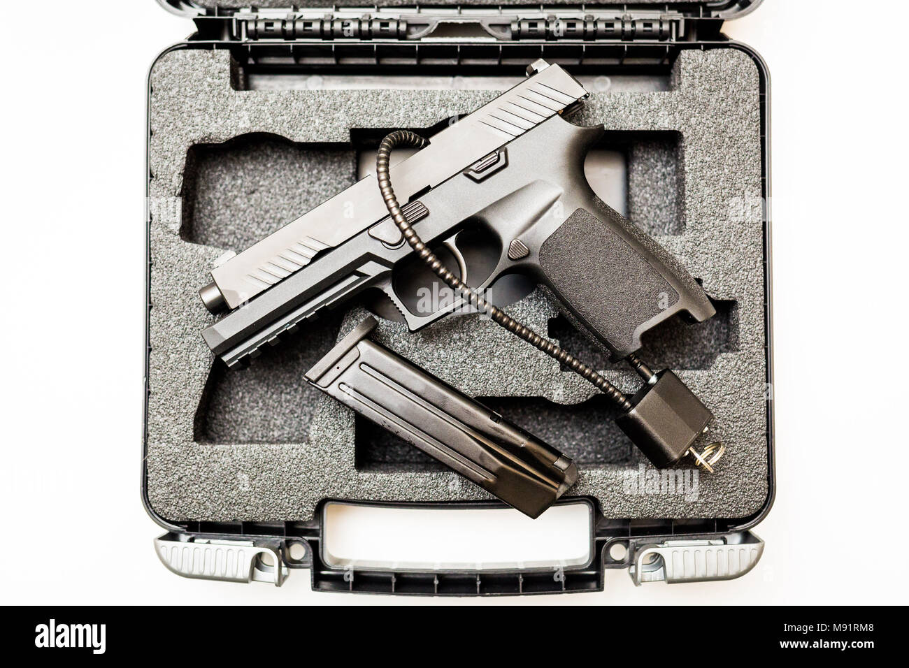 Locked disarmed secured handgun in case white background Stock Photo