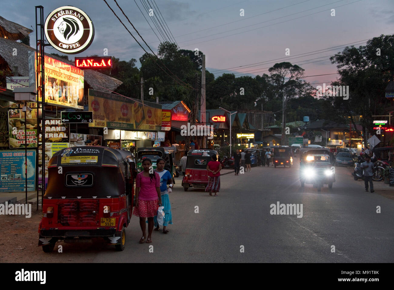 The main street in Ella evening night time with tuk tuks, restaurants, bars, tourists and locals.  Slow shutter speed and high iso so motion blur. Stock Photo