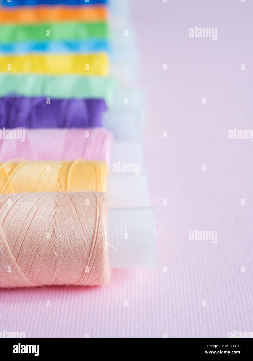 Colorful sewing buttons and thread on a pink background Stock Photo - Alamy