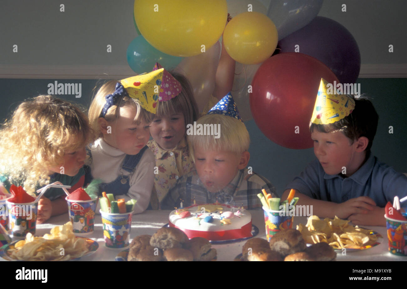 A childrens' birthday party blowing out the candles Stock Photo