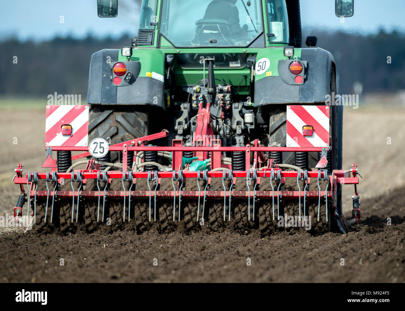 21 March 2018, Germany, Leiferde: A farmer prepares a field for the growing of potatoes with a harrow. After a longer cold perior, the farmers begin with tilling their fields. Photo: Hauke-Christian Dittrich/dpa Stock Photo