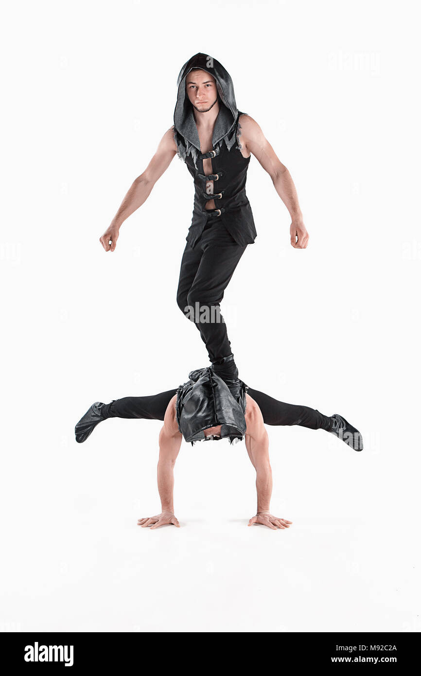 The group of gymnastic acrobatic caucasian men on balance pose Stock