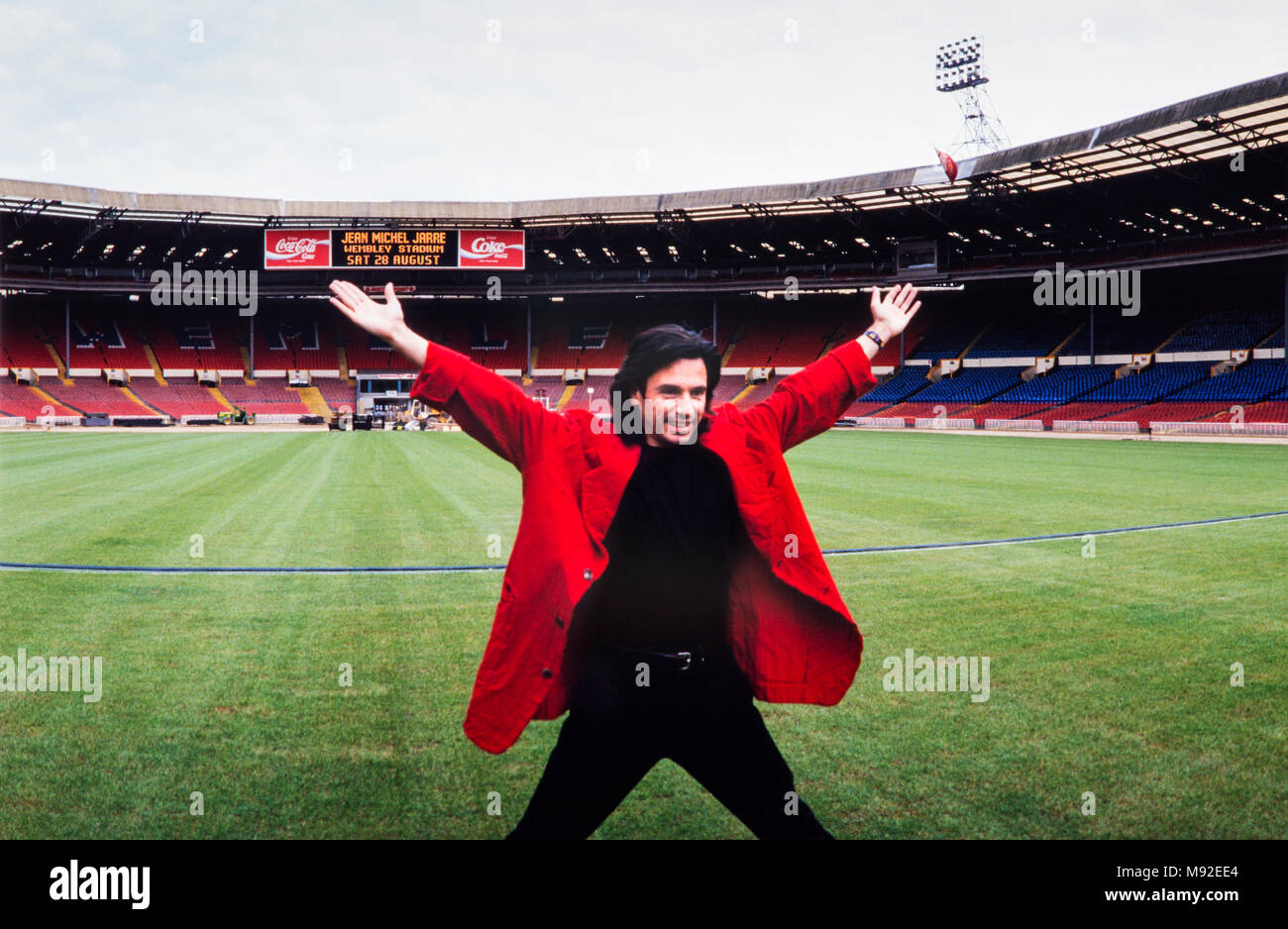 Jean Michel Jarre in red jacket, arms outstretched at a press call to promote his concert in Wembley stadium, 27th August 1993, archival photograph, London, England Stock Photo