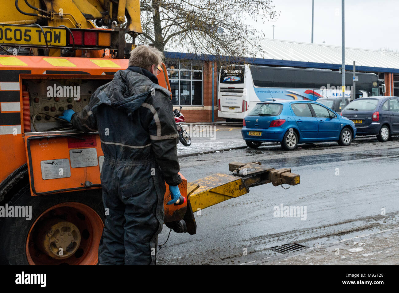 Mechanic operating the rear tow bar on his truck, collecting a National Express coach with gear problems in Pool Meadow Bus station in Coventry, UK Stock Photo