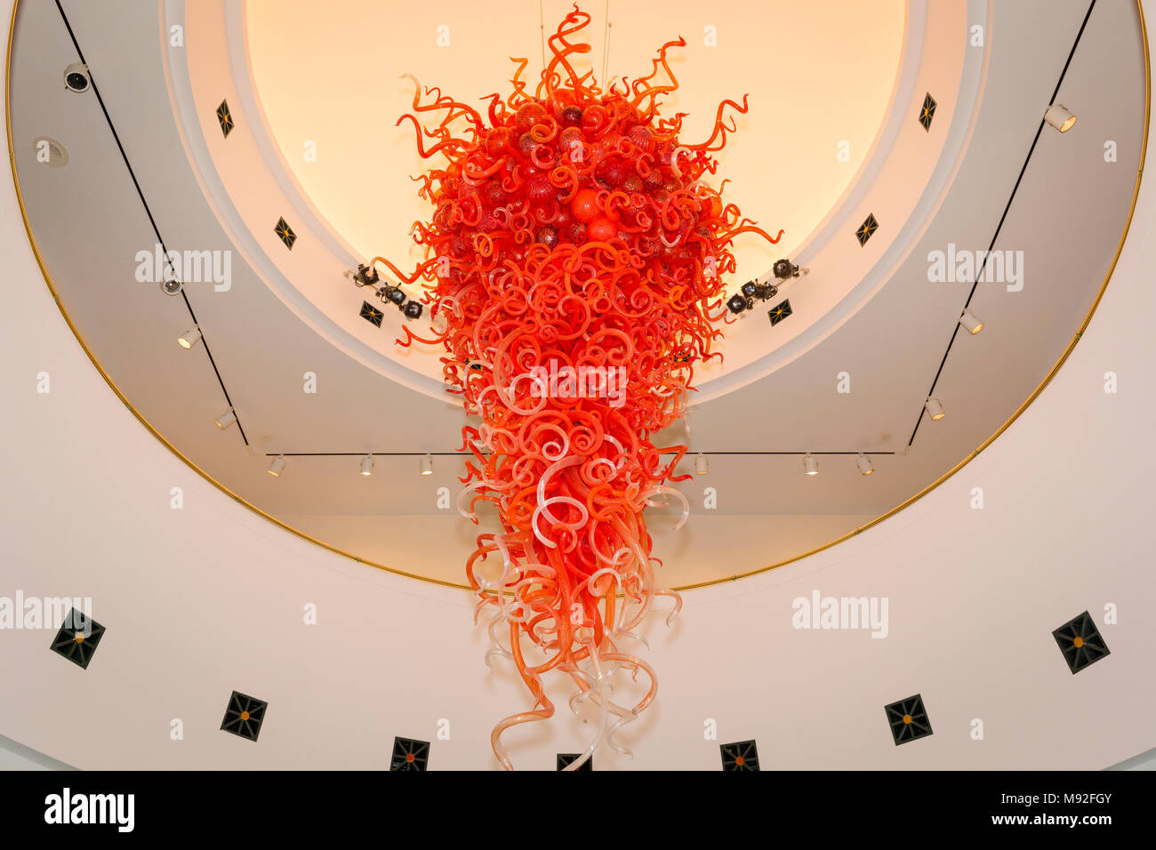 Giant hand blown, coral colored, glass sculpture hanging in the ceiling of  Artis-Naples - home of the Naples Philharmonic, Naples, Florida, USA Stock Photo