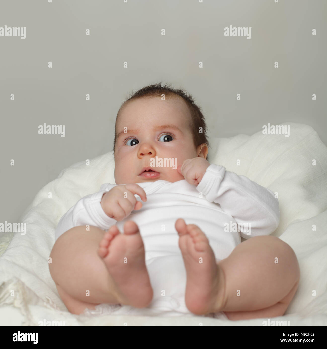 Open-eyed baby - surprised small child looking up Stock Photo