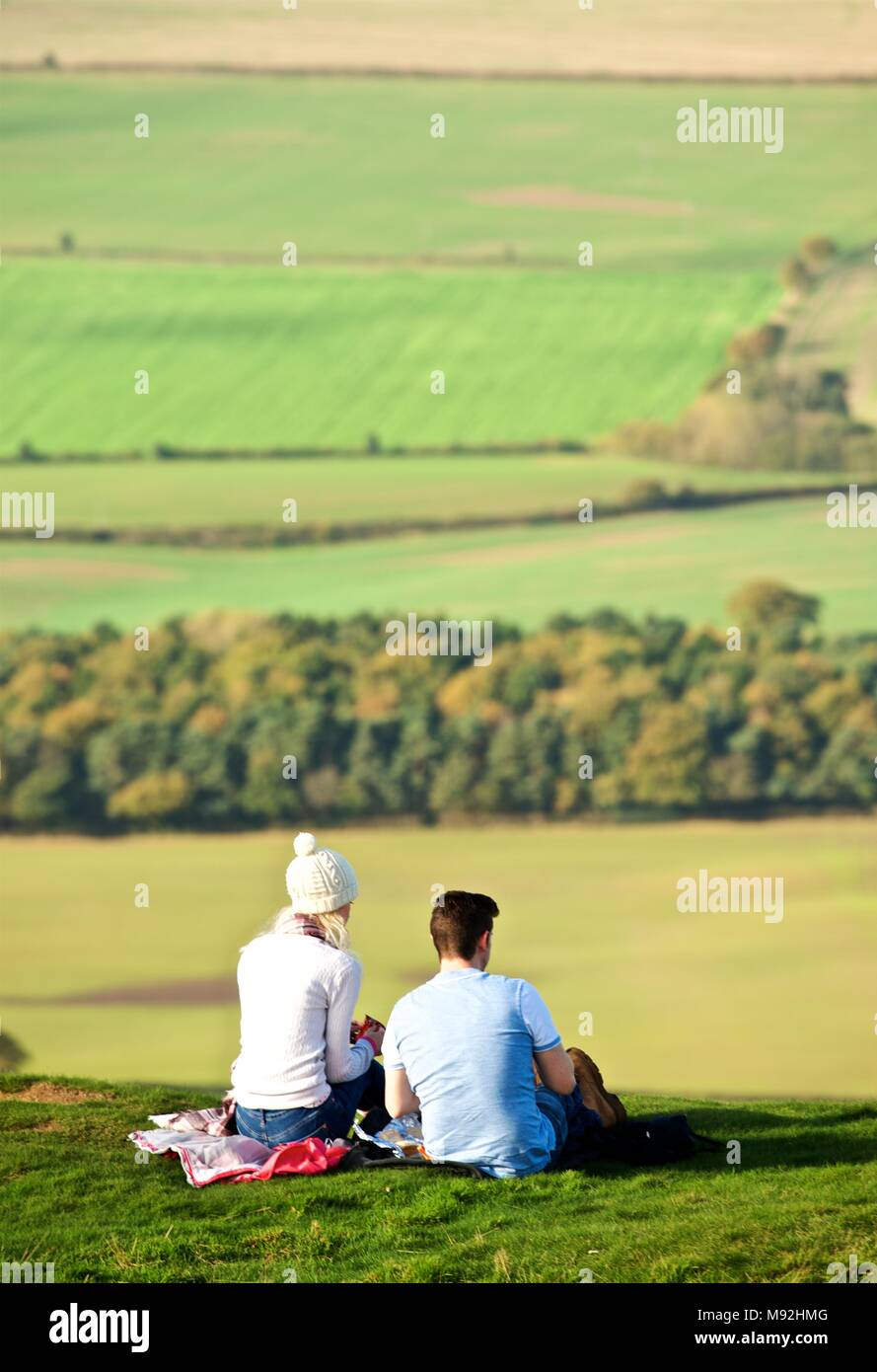 On a bright and dry Sunday afternoon in Autumn, the Wrekin attracts plenty of walkers. A young couple picnic and enjoy views over the Severn Valley Stock Photo