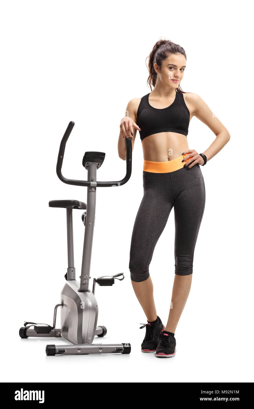 Full length portrait of a fitness woman leaning on a stationary bike isolated on white background Stock Photo