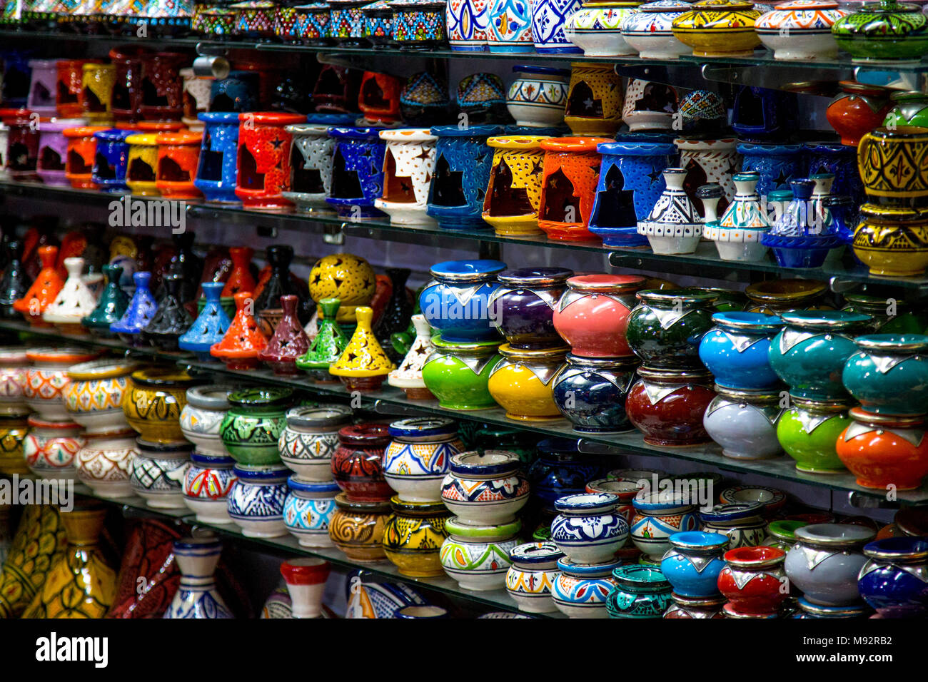 Colourful Moroccan pottery on shelves in the medina souks, Marrakesh, Morocco Stock Photo