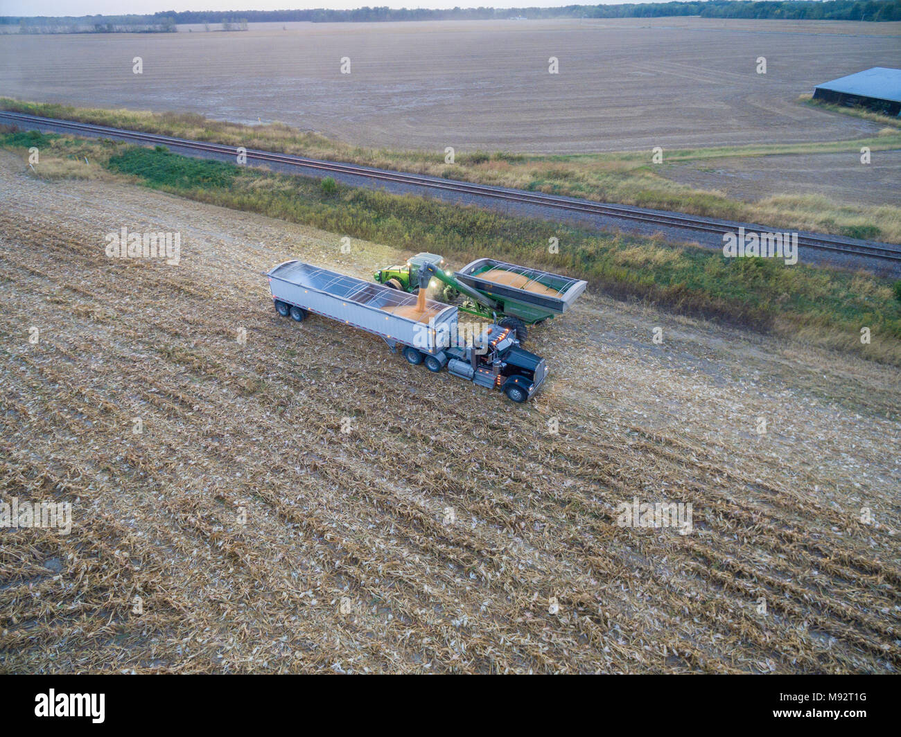 63801-08119 Corn Harvest, unloading corn into semi-truck - aerial Marion Co. IL Stock Photo