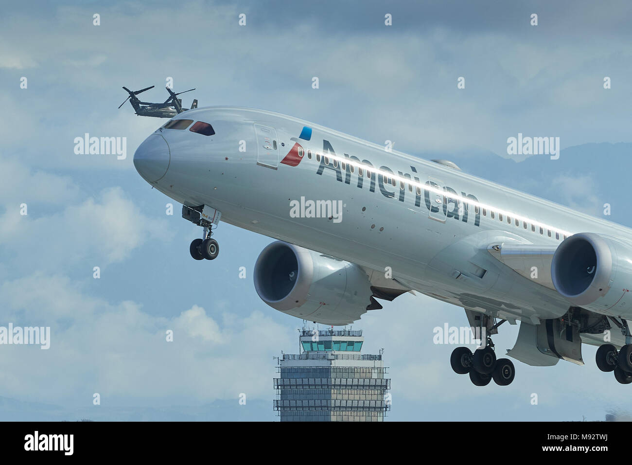 American Airlines Boeing 787-900 Dreamliner Taking Off As A US Marine Corps MV-22B Osprey Escorting President Trump Approaches Los Angeles Airport. Stock Photo