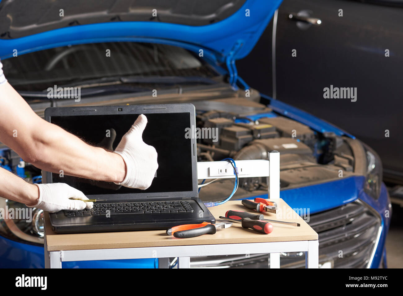 Car inspection garage mockup. Mechanic table with laptop and tools for maintenance service Stock Photo