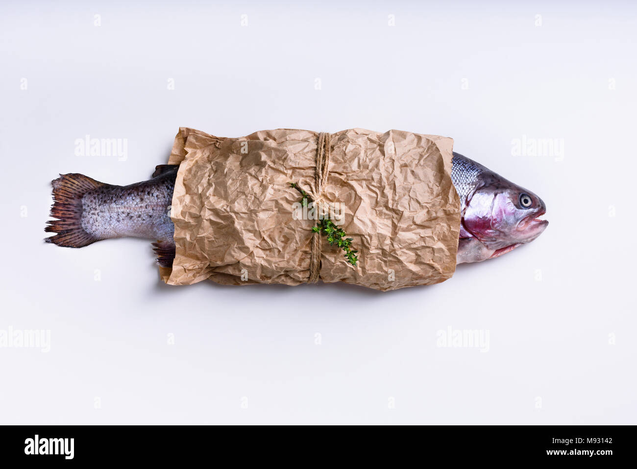 Здесь рыбу заворачивали. Рыба в бумаге. Упакованная рыба в бумаге. Во что заворачивают рыбу. Рыба на листе бумаги.