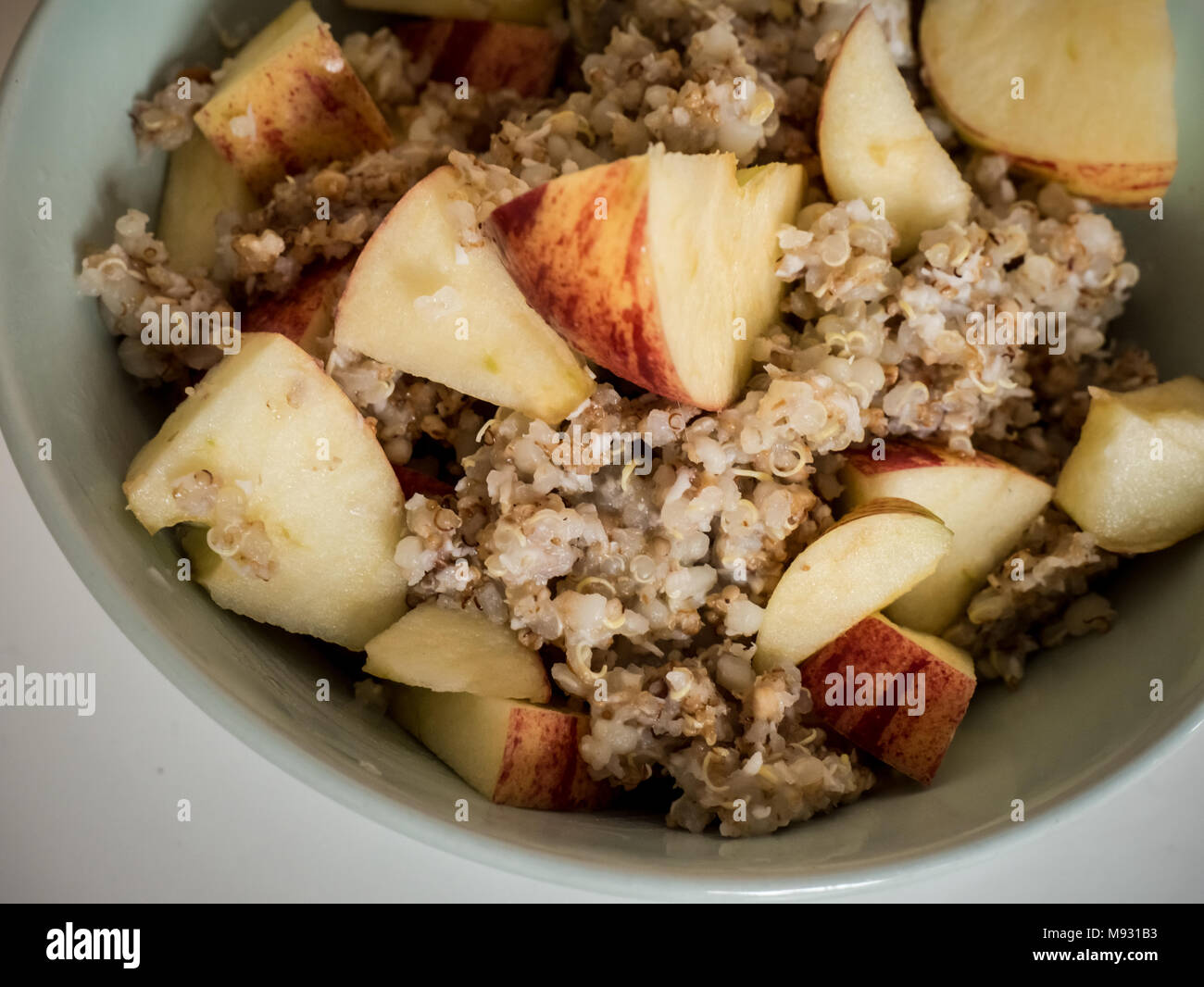 Healthy breakfast option, warm muesli with quinoa and oats and apple pieces. Stock Photo