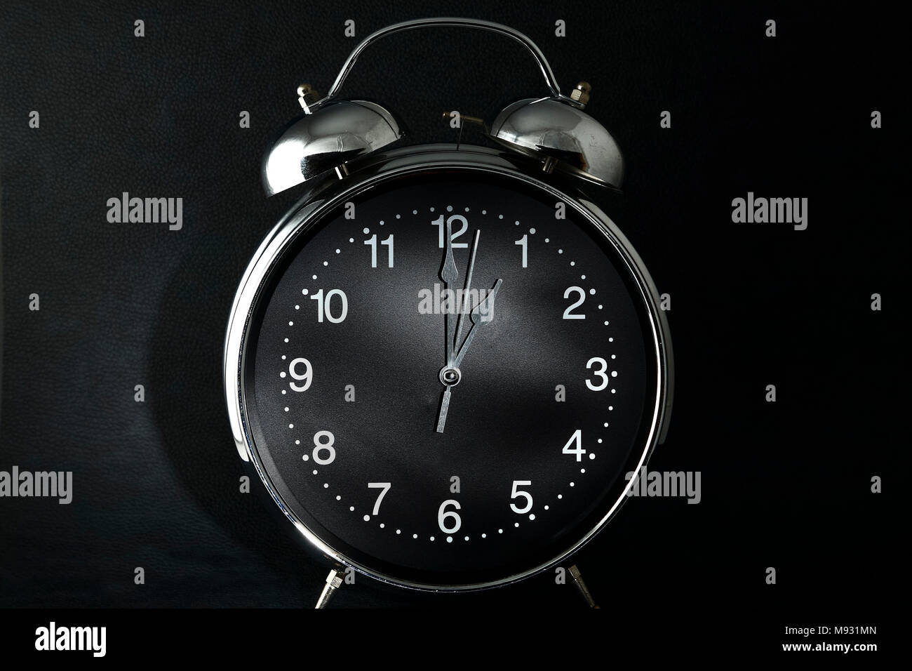 Retro style alarm clock with the hands set to one am or pm isolated on