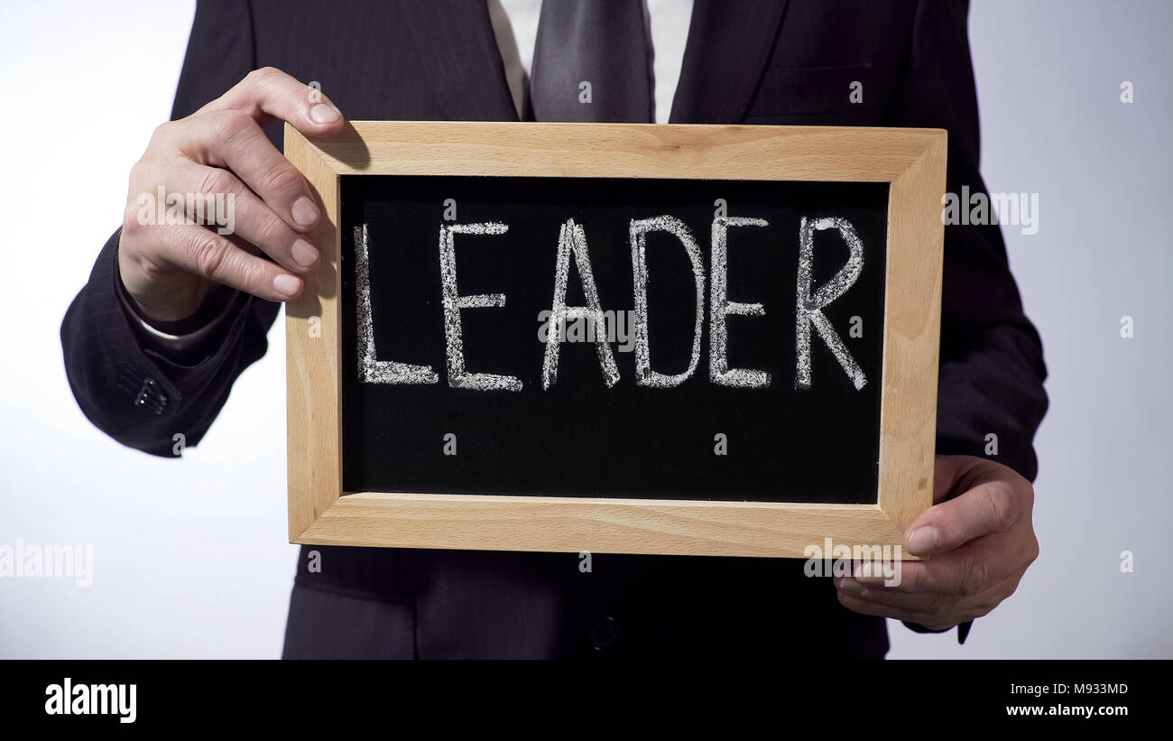 Leader written on blackboard, businessperson holding sign, business concept Stock Photo