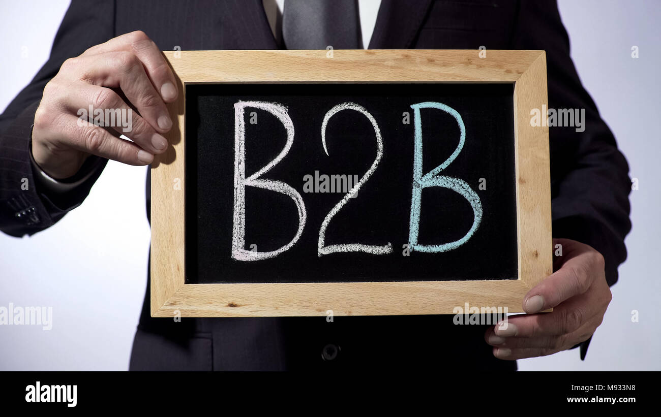 B2B, business-to-business rule written on blackboard, man holding sign, sales Stock Photo