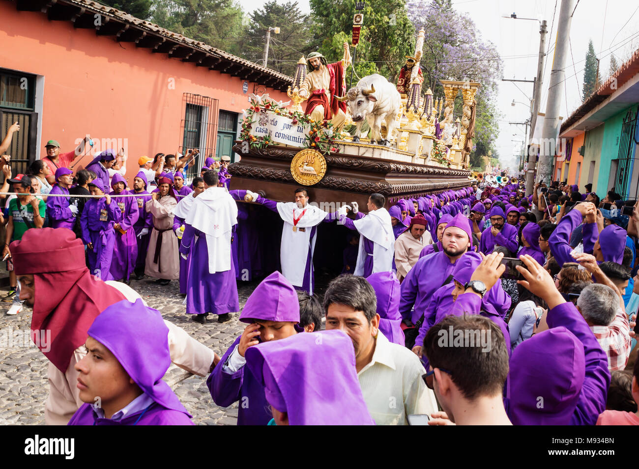 Purple robed men carrying a float with Christ and a cross at the procession of San Bartolome de Becerra, Antigua, Guatemala Stock Photo