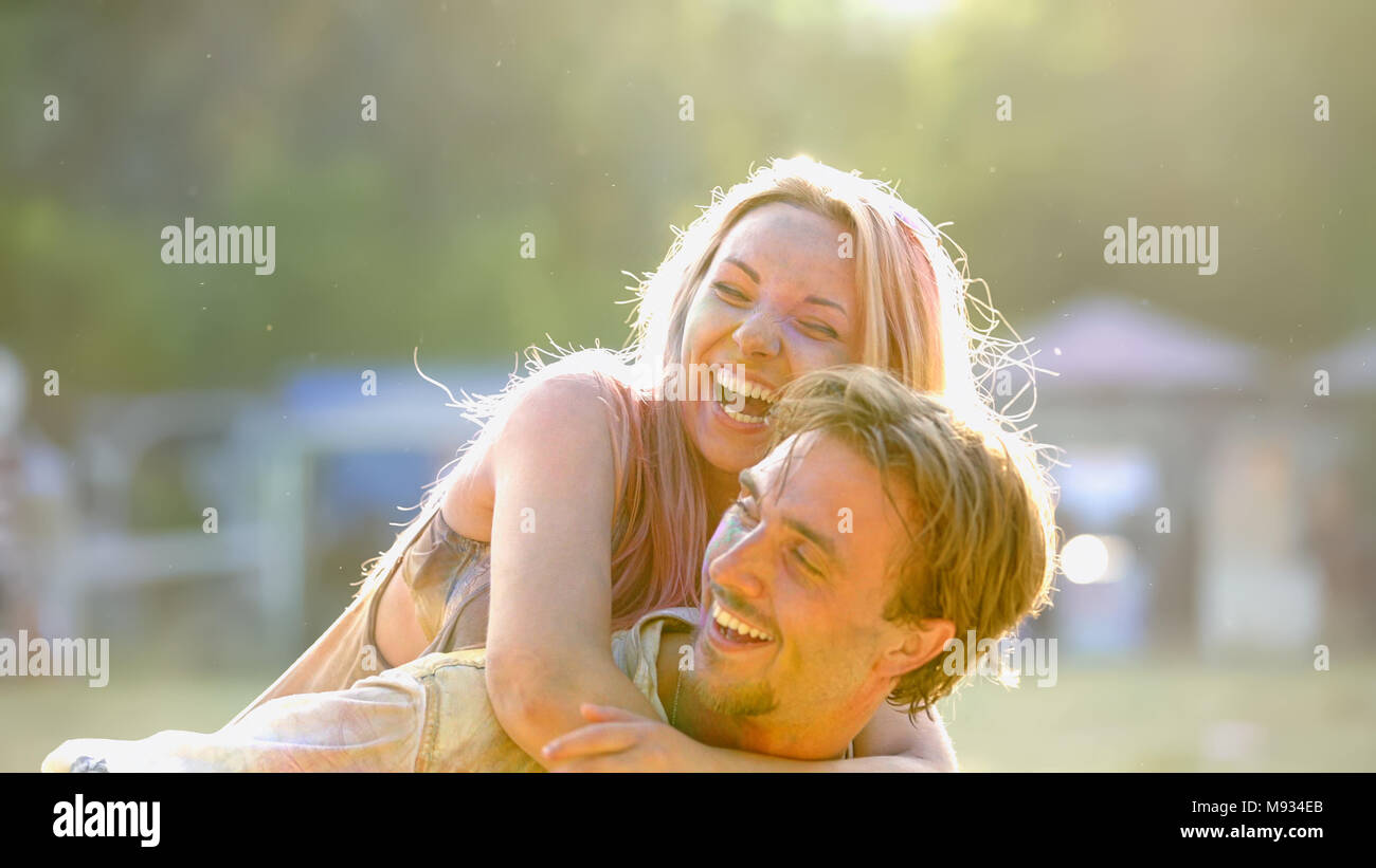 Cheerful young lady on mans back, smiling couple having fun outside, friendship Stock Photo