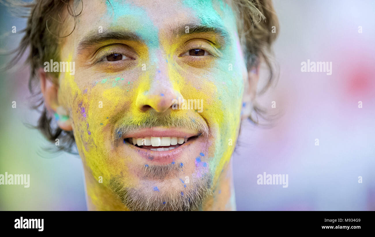 Young man with color powder on face closeup, summer festival celebration, fun Stock Photo