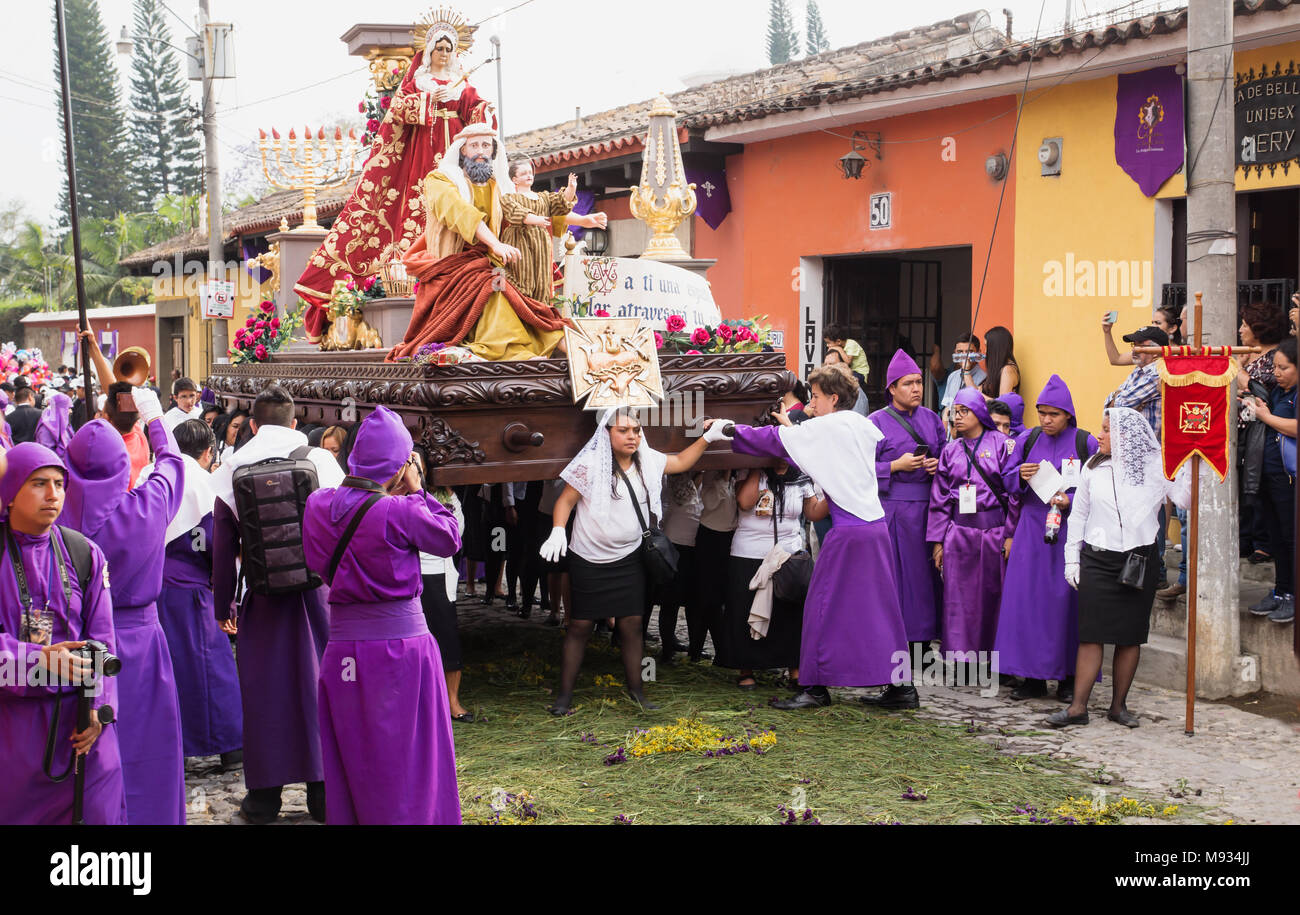 Woman in front of a float with Mary, John and Jesus on top at the procession of San Bartolome de Becerra, Antigua, Guatemala Stock Photo
