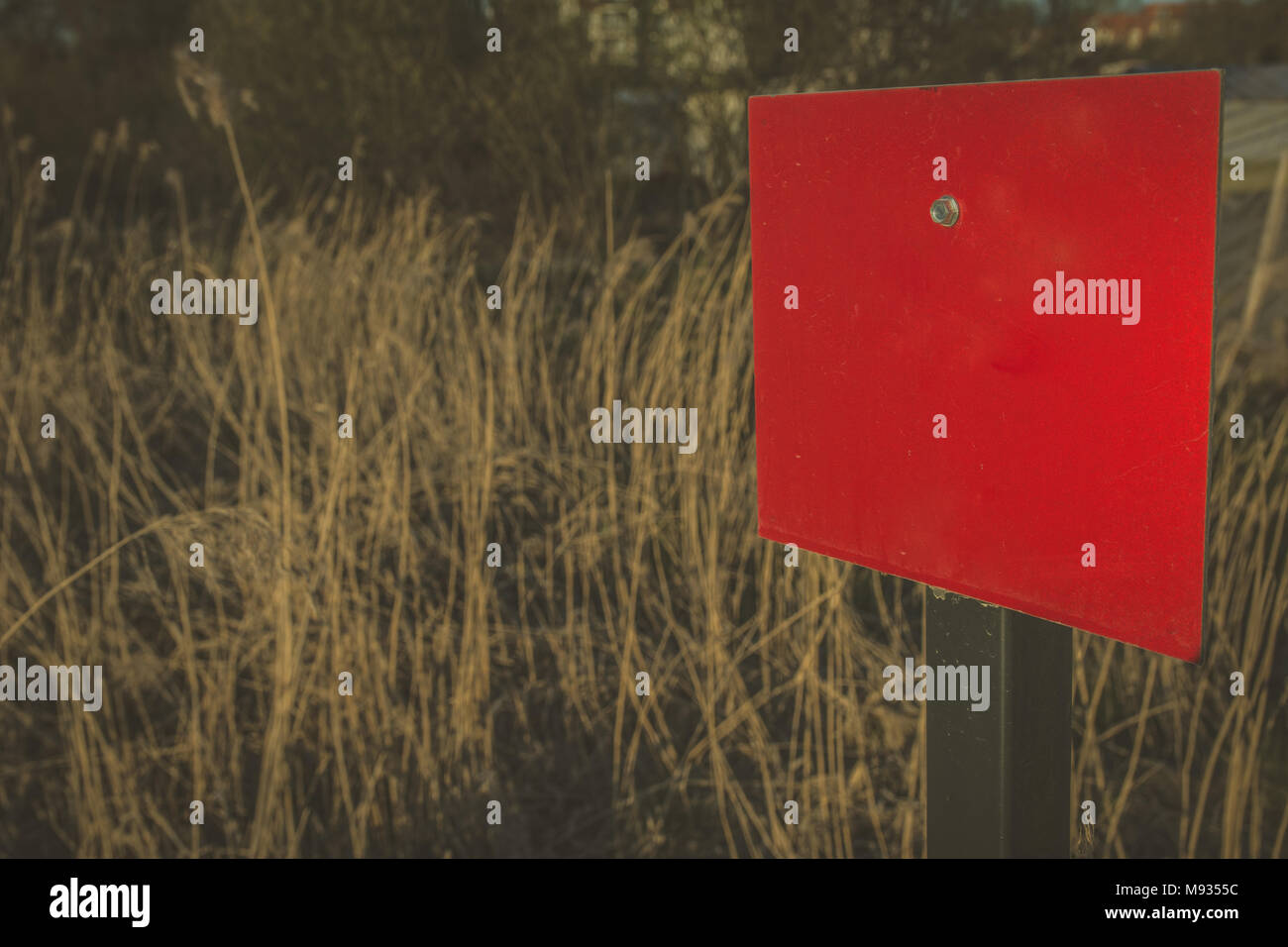 Red blank rectangular sign in the crop field with copy space to write. Vintage feel. Stock Photo