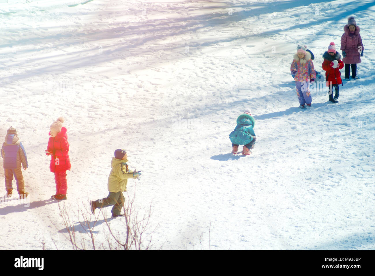 Group of children playing on snow in winter time, togetherness ...