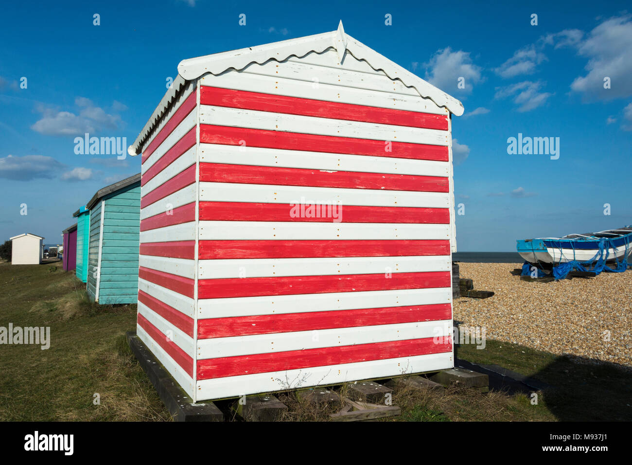 Colourful English seaside beach huts on the coast at New Romney, Kent, England, UK Stock Photo