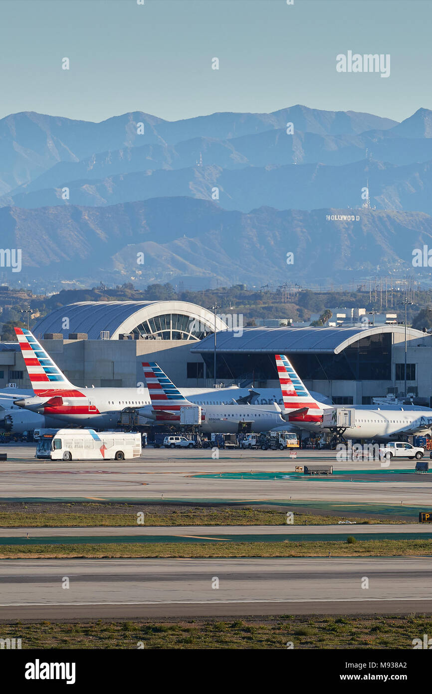 Tail Fins Of Parked American Airlines Aircraft At LAX, Los Angeles International Airport With The Hollywood Sign And The San Gabriel Mountains Behind. Stock Photo
